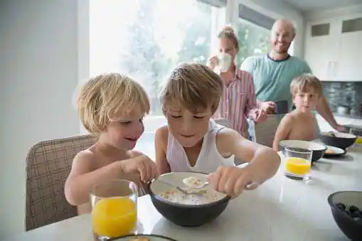 healthier children smiling couple looking at their kids eating happily